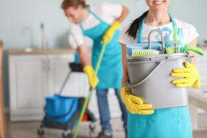 Reinigungsfachkraft mit Reinigungsmitteln in der Küche